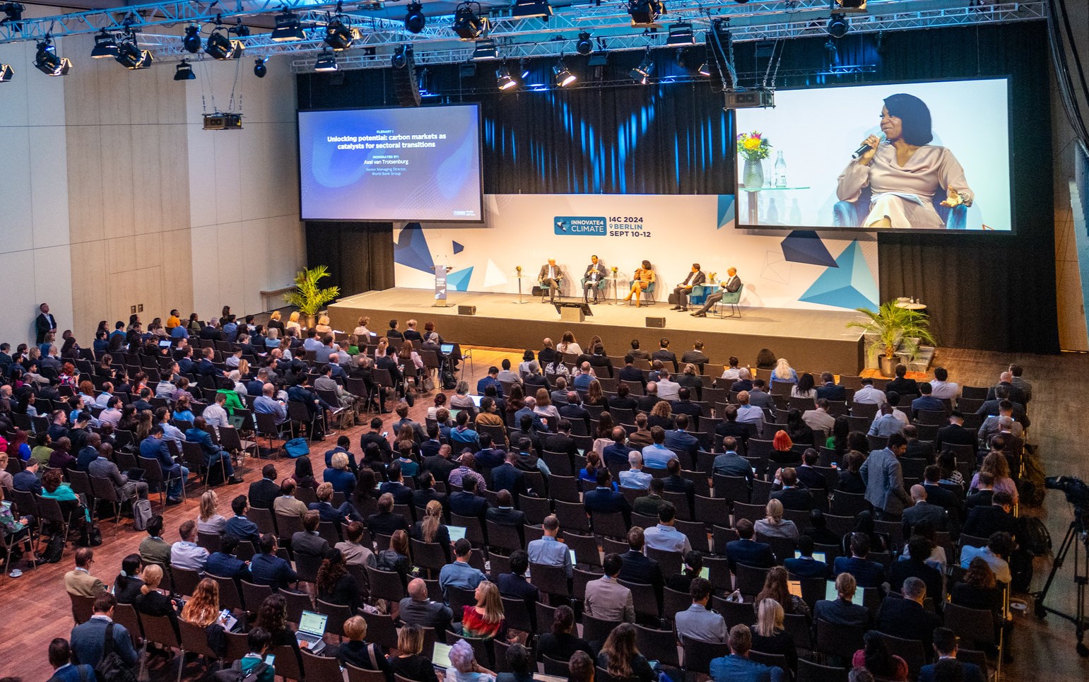 A group of people sitting in chairs in front of a stage

Description automatically generated